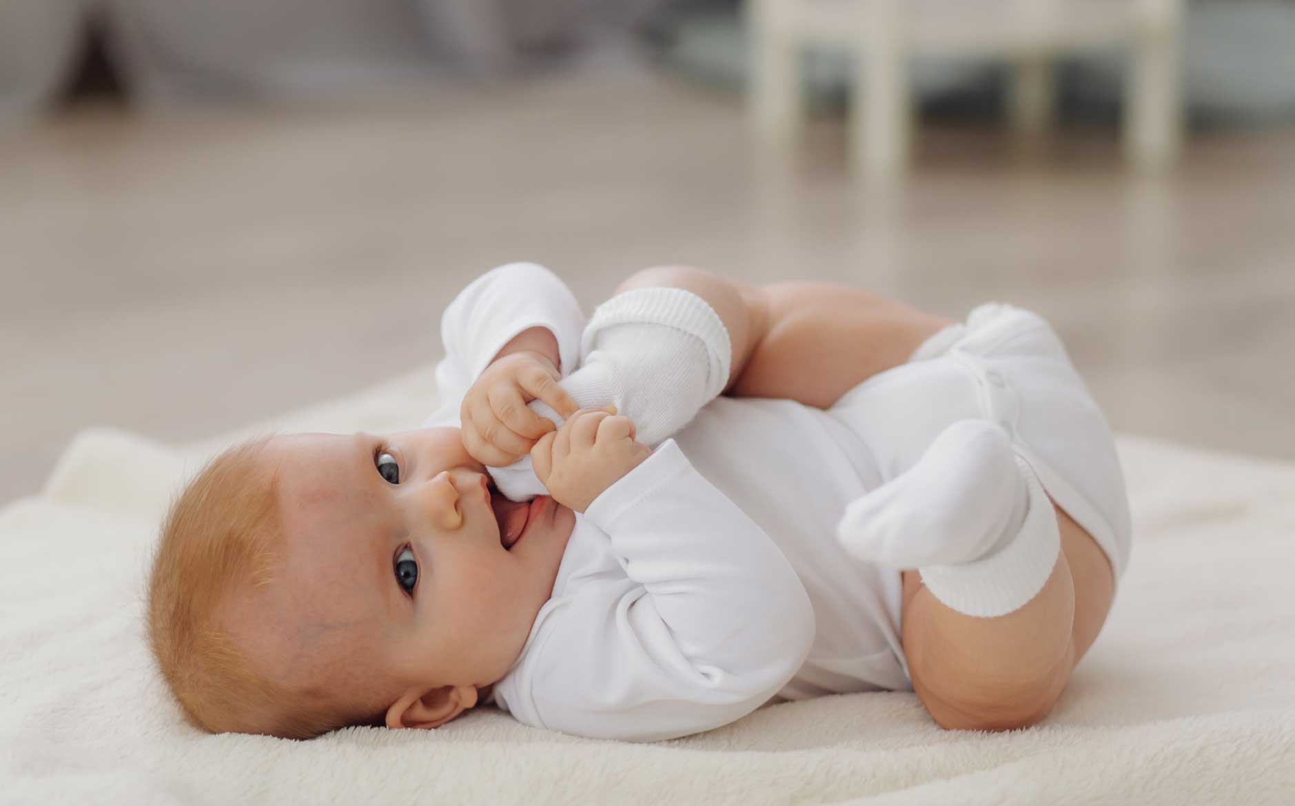 Bebé con desarrollo motriz correcto llevándose un pie a la boca